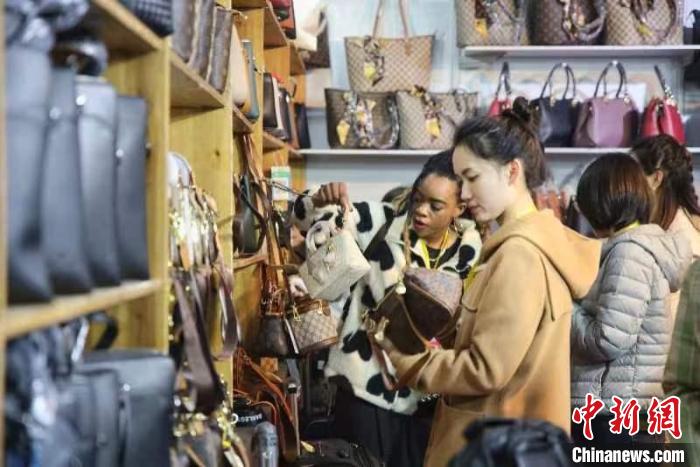 女士選購(gòu)包包?！∨砣A 攝